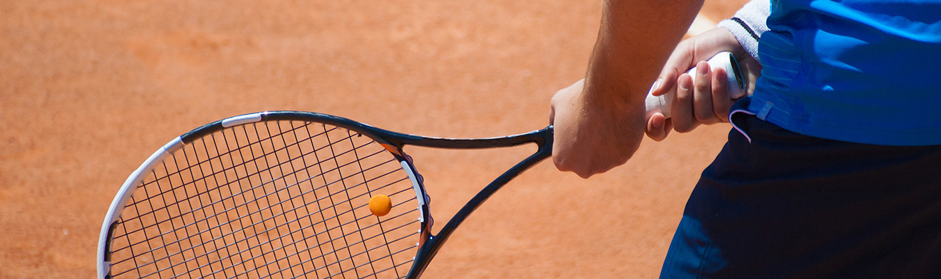 A man is holding a tennis braket